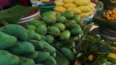 Yeşil ve sarı mangolar, Marian erikleri ve tamarindleri de dahil olmak üzere tropik meyveler Bangkok, Tayland 'da pazarda satışta. Asya 'da sağlıklı diyet yemekleri.
