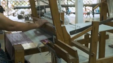 Geleneksel ipek fabrikası Chiang Mai, Tayland 'da ahşap el dokumasında beyaz ve pembe ipek iplikler dokuyor. El yapımı işçilik, tekstil üretimi sanatı, sürdürülebilir vintage