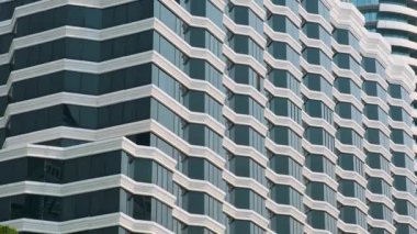 Pencereleri ve beyaz yapısal çerçeveleri olan modern yüksek binaların mimari detaylarını kapatın. Ritmik geometri, tekrarlama ve simetri, modern minimalizm. Soyut mimari