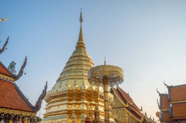Altın stupa Budist tapınağı Wat Phra Doi Suthep 'de gün batımında Chiang Mai, Tayland' da altın bir tören şemsiyesi ile. Tayland dini mimarisi. Seyahat ve turistik dönüm noktası.