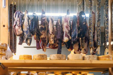 Geleneksel şarküteride çeşitli kurutulmuş, kurutulmuş et ve sosisler ahşap rafın üzerinde asılı. Küçük peynir çiftliğindeki mandıra deposu. Gıda üretim süreci.