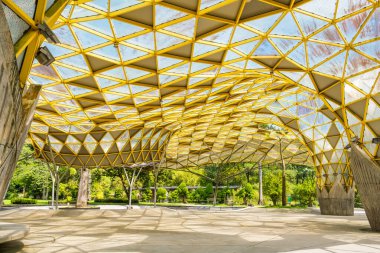 Modern geometrik sarı kafes çatı yapısı, tekrarlanan üçgen desenli. Perdana Botanik Bahçesi, Kuala Lumpur, Malezya, Asya 'da modern mimari tasarım ve soyut mimari.