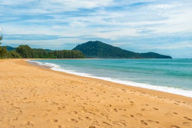 Altın kumu, turkuaz suyu ve Tayland 'ın Phuket Adası' ndaki uzak yeşil tepeleri olan tropik bir sahil. Nai Yang kumlu plajı. Asya 'da yaz tatili.