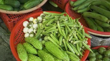 Assortment of fresh green vegetables displayed at traditional food market in Phu Quoc, Vietnam. Okra, bitter melon, white eggplant, cucumbers and long gourds displayed at Vietnamese street market