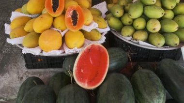 Vibrant display of fresh tropical fruits for sale at traditional food market in Phu Quoc, Vietnam. Papayas, mangoes, pomelos and watermelons displayed at Vietnamese street market. Agriculture, farming