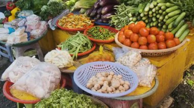 Colorful assortment of fresh vegetables and produce displayed at traditional food market in Phu Quoc, Vietnam. Cucumbers, tomatoes, eggplants, chili peppers, beans, leafy greens, mushrooms at