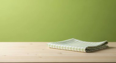 Tahta bir masanın üzerine yeşil ve beyaz kareli bir peçete yerleştirilir. Arka plan koyu yeşil bir renktir. Resim kopyalama alanına sahiptir ve yiyecek sunumu için uygundur.