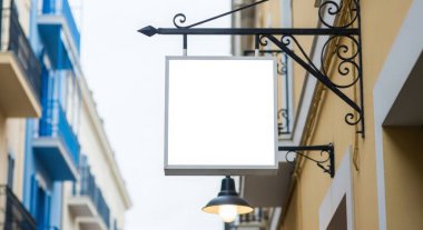 Boş bir kare tabela, şehrin bir caddesindeki bir binanın duvarına asılır. Ticari isimleri, logoları veya tanıtım mesajlarını etkili bir şekilde göstermek için çok yönlü bir model sağlar..