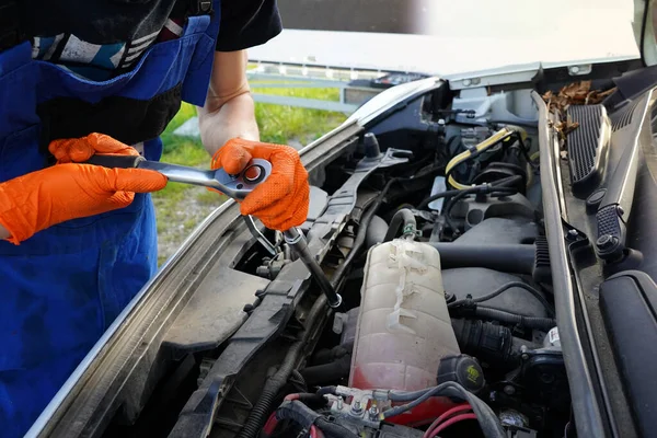 Mechanic repairing a car engine. Man fixing broken car. Oil changing in the car. Car oil change.
