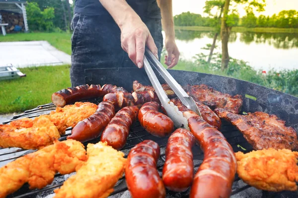 Uomo Che Gira Salsiccia Sul Barbecue Con Delle Pinze Cucina — Foto Stock