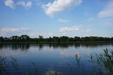 Göldeki suda bulutların yansıması. Karanlık göl manzarası.