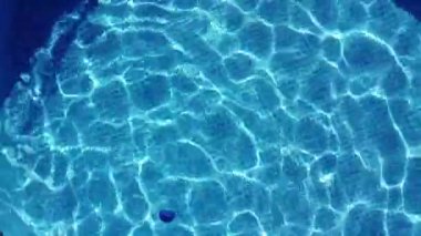 Yüzme havuzu. Havuzda hareket eden kristal suyun üst görüntüsü. Sıcak yaz tatili. Havuzda yüzmek..