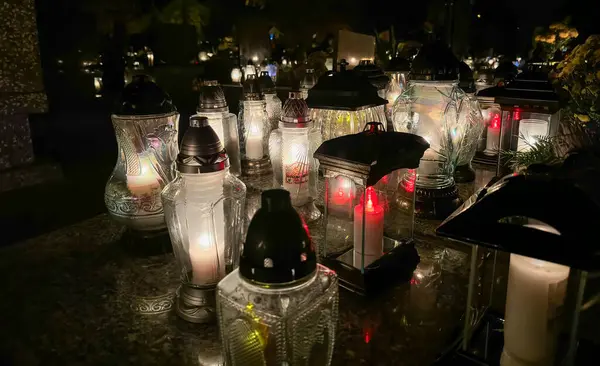 Azizler Günü 'nde mezardaki mumlar. Güzel ışıkları ve çiçekleri olan mezarlık mumları. Tüm ruhlar günü boyunca mezarlık.