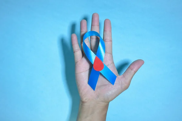 顶部视图蓝带意识到与红血滴在人的手隔离在蓝色背景 11月14日世界糖尿病日复制空间 — 图库照片
