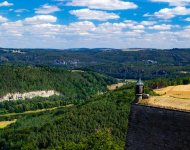 Ağaçlı bir nehir vadisinde bir kale kulesi.