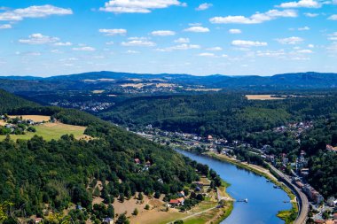 Dağlardaki nehir kıyısında bir şehir.