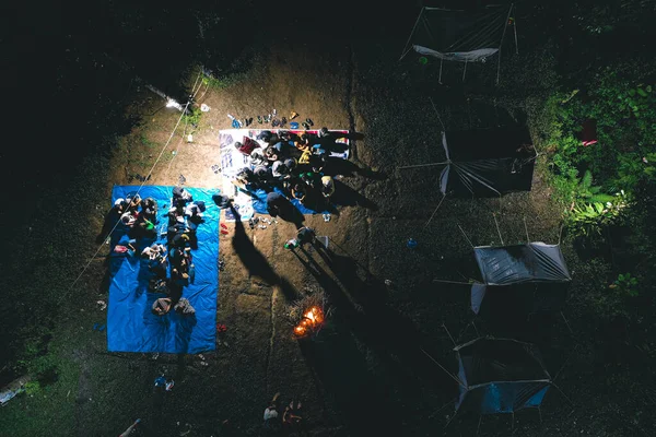 キャンプファイヤーを照らしながら森の真ん中に一緒に学生キャンプ活動の空中ビュー — ストック写真