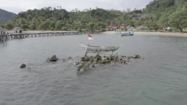 Sahile yakın bir teknenin görüntüsü, Batı Sumatra, Pesisir Selatan 'ın büyüleyici doğal güzelliğini gösteriyor..