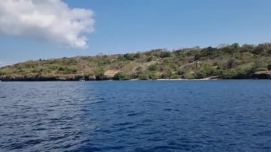 Denizden geçen küçük bir tekneden Menjangan Adası manzarası