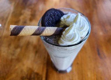 Tahta masada kurabiyeli milkshake çikolatalı smoothie, seçilmiş odak bulanık arkaplan