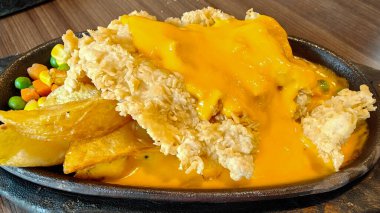 Kızarmış patates kızartması ve siyah ahşap tabakta sebzeli kızarmış tavuk bifteği.