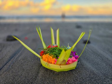 Canang on the beach, a tradition of offerings in Bali clipart