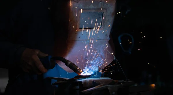 Welding of steel, sparking, not wearing gloves but with a protective mask.danger at work, protection at work. close-up photo of sparks during steel welding