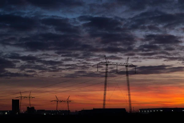 power lines at abstract sunset.silhouettes of power lines and factories in the industrial zone.in the background are the beautiful colors of the sunset