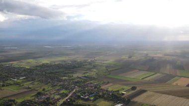 aerial view. the change of sun and clouds above the village in the plain.the sun's rays streak across the ground of the plain.an abstract scene of the play of nature.Timelapse video.abstract nature