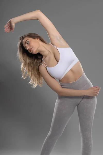 Fitness Vrouw Doet Stretch Oefening Studio Met Grijze Achtergrond — Stockfoto