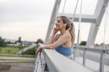 Güler yüzlü kadın, tugaydaki eğitimden sonra müzik dinliyor.