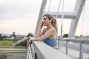 Güler yüzlü kadın, tugaydaki eğitimden sonra müzik dinliyor.