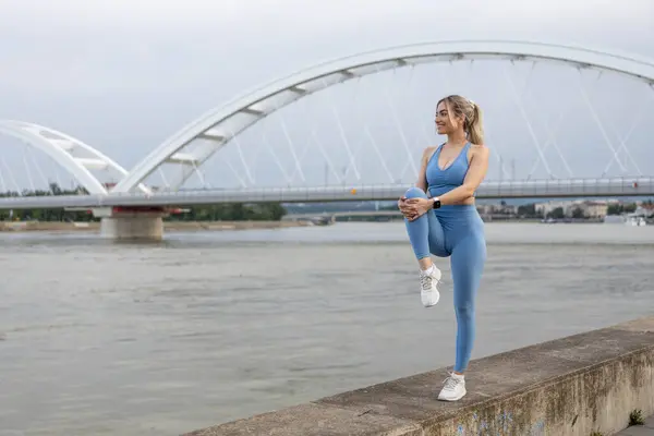 Spor elbiseli genç bir kadın dışarıda idmandan sonra esniyor.