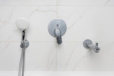 Kirli duş musluğu kireç ve sabun lekeleriyle kaplı.