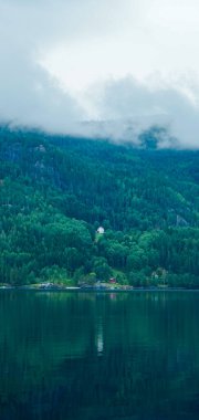 Yalnız ev gölde yansıyor, Norveç 'te sakin bir sabah.