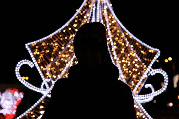 Parktaki siluet Noel için dekore edilmiş, siyah arkaplan.