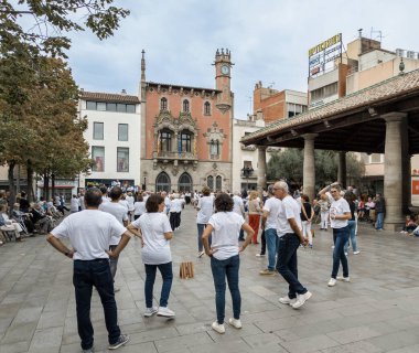 Granollers, Katalonya, İspanya; 23.10.2022: Granollers 'dan Sardanista grubu, arka planda dinleyici kitlesi ve müzik çalan bir orkestrayla Granollers sundurma meydanında dans etmeye hazırlanıyor