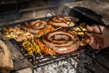 Güneşli bir günde mangalda sosis ve tavuk şişi ile yapılan yemeğin ızgara detayları.