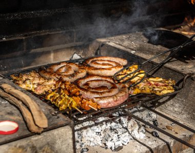 Güneşli bir günde mangalda sosis ve tavuk şişi ile yapılan yemeğin ızgara detayları.