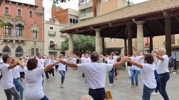グラノラーズ カタルーニャ スペイン 2022 グラノラーズのポーチ広場で踊るグラノラーズ出身のサワニスタグループのビデオを背景に観客とオーケストラが音楽を演奏 — ストック動画