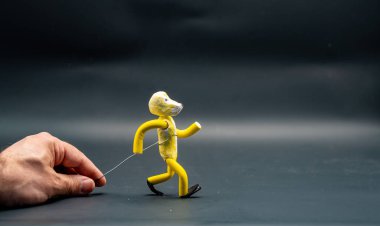 Yürümeyi durdurma süreci. Üçüncü adım. Alüminyum bir kabloyla el ele tutuşan bir adam sarı modelleme macunuyla yapılmış bir figür yürüme sürecini başlatıyor. Animasyonun 12 ilkesi.