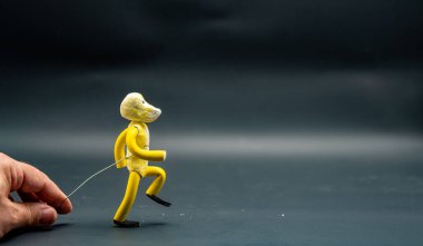 Yürümeyi durdurma süreci. Dördüncü adım. Alüminyum bir kabloyla el ele tutuşan bir adam sarı modelleme macunuyla yapılmış bir figür yürüme sürecini başlatıyor. Animasyonun 12 ilkesi.