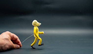 Yürümeyi durdurma süreci. Beşinci adım. Alüminyum bir kabloyla el ele tutuşan bir adam sarı modelleme macunuyla yapılmış bir figür yürüme sürecini başlatıyor. Animasyonun 12 ilkesi.