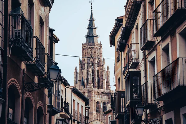 Narrow street of historic city with windows where at the end is the cathedral of Toledo