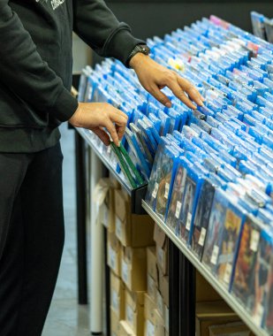 Bir film koleksiyoncusunun dükkanındaki rafta bulunan film ve DVD 'leri ve film CD' lerinin satışını arayan ve seçen eller.