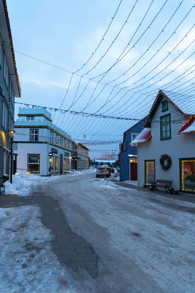 クリスマスライトや装飾品で照らされたセルフの旧市街の古典的なお店や日没時の雪と氷の通り — ストック写真