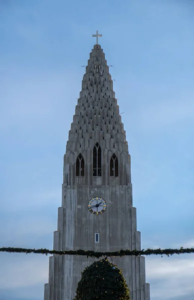 アンテナの詳細を見ることができるハルグリムスカルカ教会の上部の詳細 その観点からレイキャヴィクの写真を撮る十字架と観光客 — ストック写真