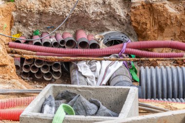 Yeraltı tedarik hatları ve borular yeraltına döşenmiş ve inşaat alanındaki siperlere döşenmiş. PVC Borusu.