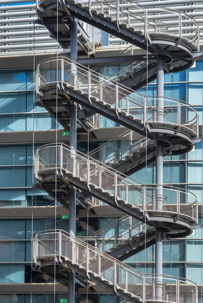 Zig zag iron stair for fire escape outside modern metal industrial building fence outdoor.