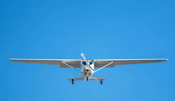 在萨巴德尔机场着陆前 在晴朗的天空中飞行的白色小飞机 带有蓝色条纹的塞斯纳螺旋桨 — 图库照片